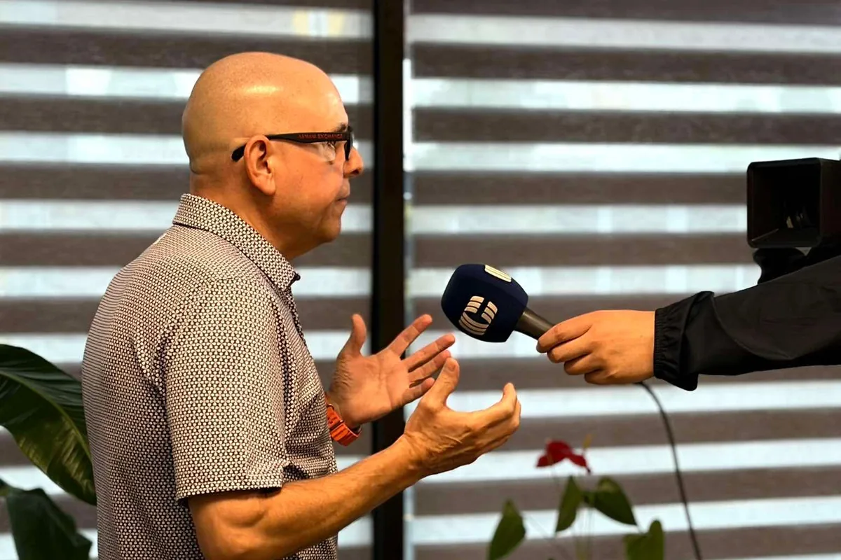 Paul Meyers mid-answer, gesturing with both hands as a Cogeco microphone is held toward him