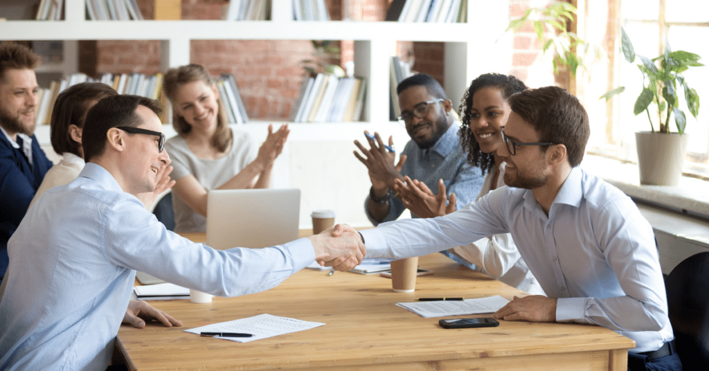 A digital marketing agency team shaking hands with a happy client.