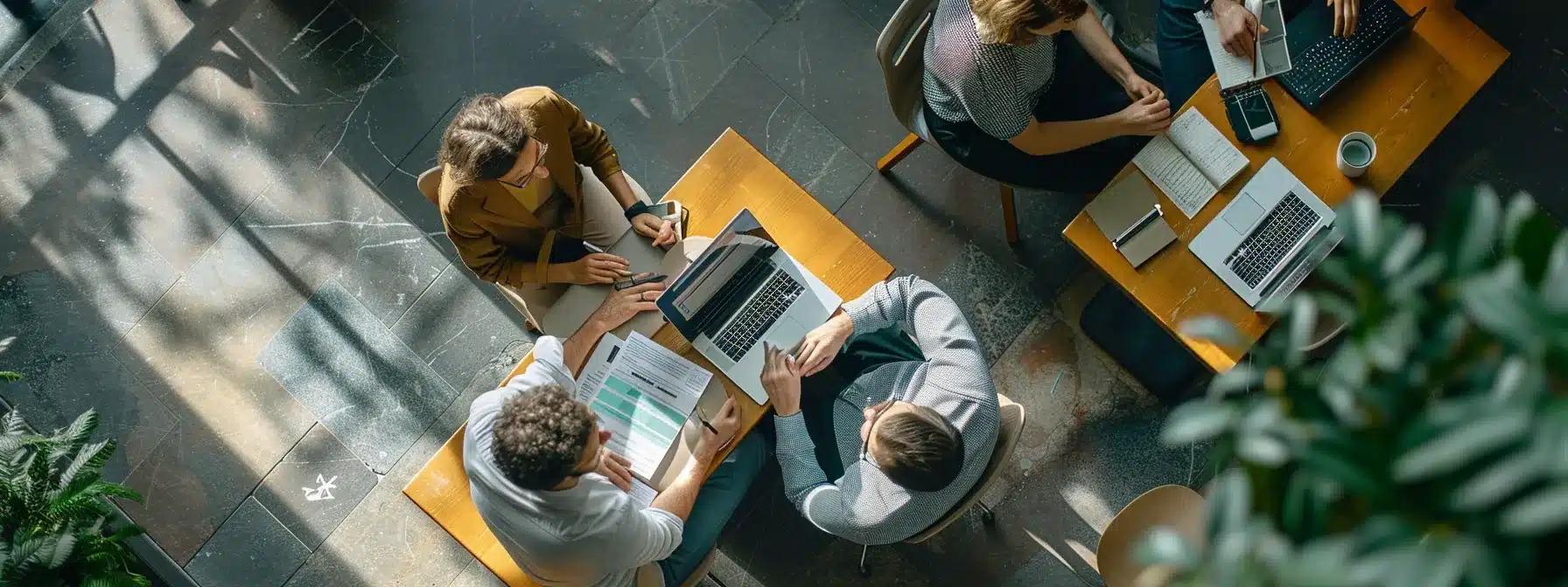 a group of people working together on laptops and tablets, discussing a local business' seo strategy.